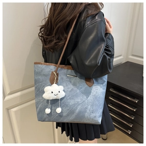 Light blue denim tote bag with brown leather handles and a cute cloud charm on shoulder