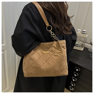 Detail of coffee brown quilted tote bag with gold chain and suede finish leather