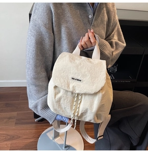Detail of off-white nylon backpack featuring drawstring closure and brand woven label