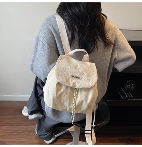 Detail of off-white nylon backpack with drawstring flap and texture fabric texture