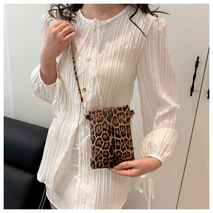 Detail view of stylish leopard print mobile phone bag with slim metal chain strap