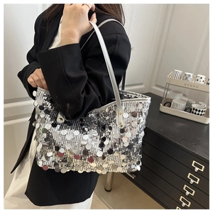 Borsa tote con paillettes argento e grandi scaglie rotonde portata a spalla da una modella