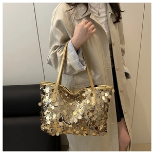 Detailed shot of a gold sequin tote bag with shimmering circular discs and metallic handles