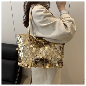 Detail of a gold sequin tote bag with shiny metallic texture and comfortable shoulder strap