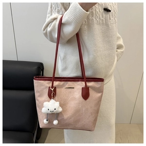 Detail of pink marble pattern tote bag with red straps and plush cloud charm accessory