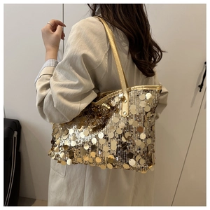 Dettaglio di grandi paillettes dorate su una borsa tote con spalline sottili
