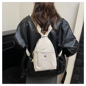 Rear view of model wearing a stylish off-white nylon backpack with adjustable straps