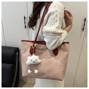 Detail view of pink tote bag with red leather straps and white cloud plush charm