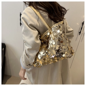 Detailed shot of large golden sequins and faux leather strap on a stylish tote bag