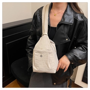 Detail of off-white crossbody chest bag with crinkle nylon texture and round metal logo
