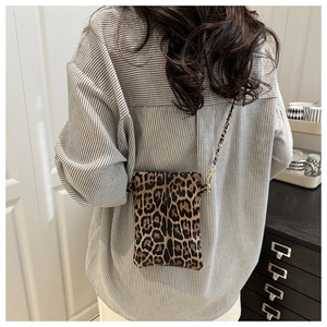 Leopard print crossbody phone bag styled with a striped shirt for a trendy look