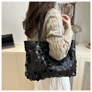 Detailed view of large black sequins on tote bag with metallic rivet handle detail