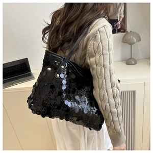 Dettaglio della borsa tote nera con paillettes lucide e tracolla in pelle morbida