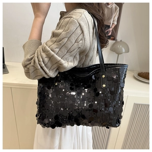 Dettaglio ravvicinato delle paillettes nere lucide e del cinturino in pelle con borchie oro