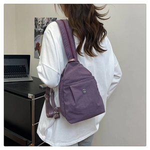 Detail view of a versatile deep purple nylon crossbody bag showing strap and texture