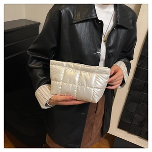 Detail of white quilted puffy handbag with metallic finish and modern padded design