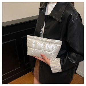 Détail d'une trousse de maquillage blanche matelassée avec finition métallique brillante