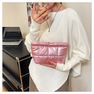 Gros plan sur pochette matelassée rose métallisée avec détails de broderie chic