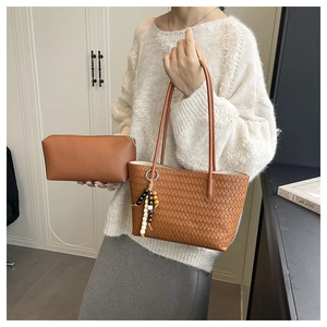 Detail of brown woven tote bag with smooth leather clutch and decorative wooden beads