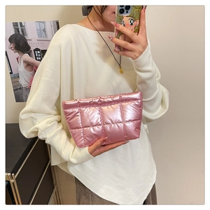 Détail d'un sac à main rose matelassé avec finition métallisée et motif à carreaux