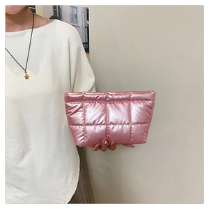 Détail d'une pochette matelassée rose métallisé avec fermeture éclair dorée et coutures