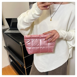 Close-up of pink shiny quilted handbag with metalic finish and square stitching details