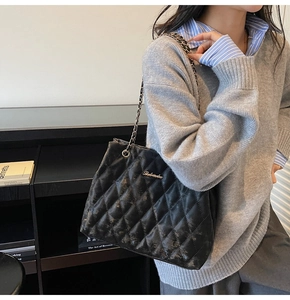 Chic quilted crossbody bag in black with silver logo and woven chain strap details