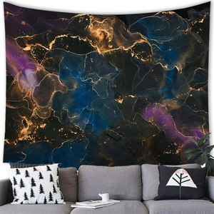 Modern abstract tapestry with blue and gold fluid marble art hung over a gray sofa