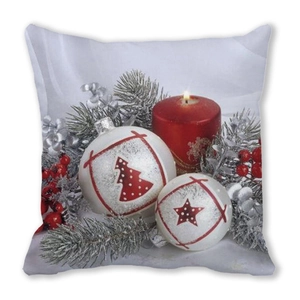 Detail of Christmas pillow cover with red candle, festive ornaments and winter berries