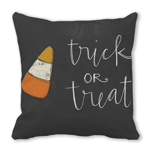 Close-up of Trick or Treat Halloween pillow cover with candy corn pattern on dark fabric