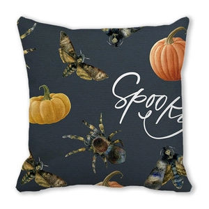 Detail of grey Halloween pillow with Spooky text, pumpkin, moth and spider patterns