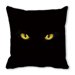 Nahaufnahme eines schwarzen Halloween-Kissenbezugs mit leuchtend gelben Katzenaugen