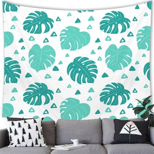 Détail d'une tapisserie murale aux feuilles de monstera au-dessus d'un canapé gris moderne