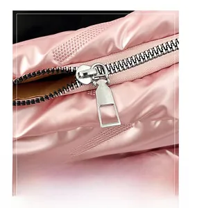 Detail shot of durable silver metal zipper on pink quilted down handbag fabric