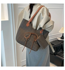 Détail du cabas vintage avec motif monogramme et petit sac assorti suspendu