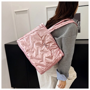 Detail of pink quilted puffer tote bag made of lightweight nylon with soft padded straps