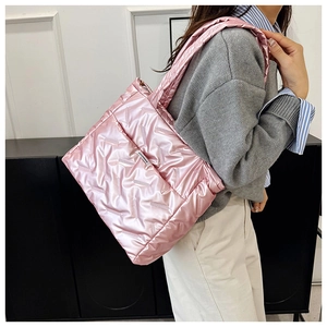 Detail of pink glossy quilted puffer tote bag with Fashion & Bag label on shoulder