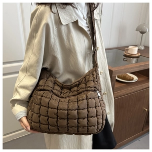 Gros plan d'un sac bandoulière matelassé marron avec rembourrage et fermeture éclair