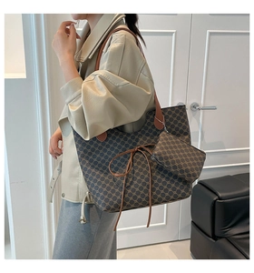 Détail du sac cabas vintage à monogramme avec lanières en cuir marron et pochette assortie