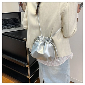 Detail of silver metallic bucket bag with drawstring closure for daily commuting style