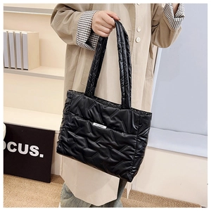 Detail of black quilted puffer tote bag made of lightweight nylon with fashion label