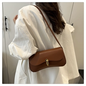 Brown leather handbag with gold U-shaped buckle shown from a stylish side view angle