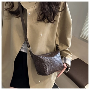 Detailed view of dark brown woven leather crossbody bag with adjustable shoulder strap