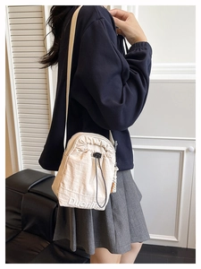 Detail of off-white crossbody bag featuring Duoning embroidery and drawstring closure
