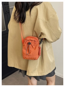 Détail du sac bandoulière orange avec cordon de serrage, broderie Duoning et nylon