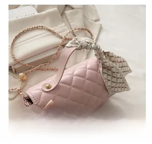 Pink quilted crossbody bag detail with silk scarf wrapped handle and gold chain strap
