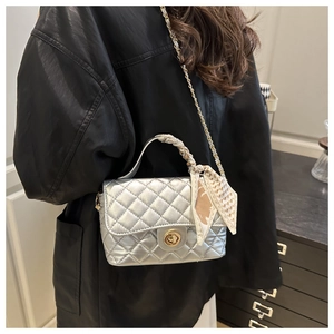 Detail of silver quilted crossbody bag with silk scarf handle and gold chain strap