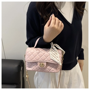 Detail of pink quilted box bag with silk scarf handle and golden chain strap