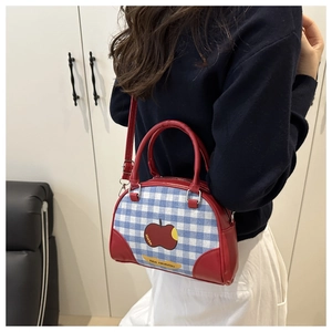 Detail of Korean-style bowling bag with red apple print and blue plaid fabric panels