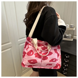Détail du sac cabas léopard rose avec deux poches avant et anses en toile crème